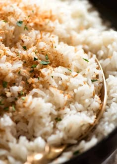 white rice in a black bowl with a spoon