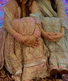 two women sitting next to each other on a rug