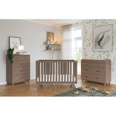 a baby's room with two dressers and a crib