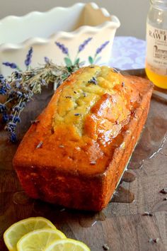 a loaf of bread sitting on top of a cutting board next to sliced lemons