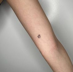 a person's arm with a small tattoo on the left side of their arm