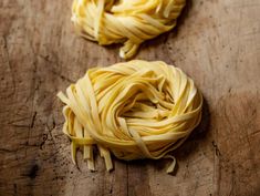 two uncooked noodles on a wooden surface