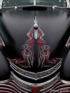 the front end of a classic car with an intricate design on it