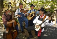 three men are playing music in the woods