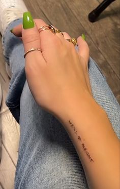 a woman's hand with a green manicure on her left wrist and the word love is written on it