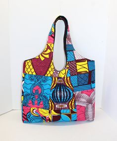 "This Bag is designed for both style and comfort. With its stylish look and practical storage, this bag can carry all sorts of things without any worries! Its spacious opening allows for easy access to your belongings. It is made with 100% cotton African Print fabric, fleece interface, and black canvas lining. MEASUREMENT: 16\" WIDTH X 16\" HEIGHT X 5 1/2\" DEPTH (WITHOUT HANDLE) FEATURES: 2 slide pockets 1 zipped pocket Magnetic snap closure See my other bags in this size here: https://www.etsy Multicolor Reversible Rectangular Shoulder Bag, Reversible Square Bags, Large Multicolor Shoulder Bag For Daily Use, Multicolor Reversible Shoulder Bag, Trendy Tote Bag With Magnetic Closure, Reversible Square Shoulder Bag For Shopping, Multicolor Reversible Square Shoulder Bag, Reversible Shoulder Bag For On-the-go, Reversible Square Shoulder Bag