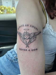 a woman with a tattoo on her arm saying,'always an angel never a god