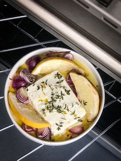 a bowl filled with lemons, onions and cheese on top of an oven rack