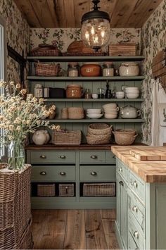 an old fashioned kitchen with green cabinets and baskets on the shelves, along with wicker baskets