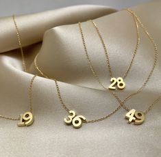 "Tiny gold number charms on a delicate 14k gold-filled chain.  This necklace is perfect for everyday wear, whether you want to showcase your lucky numbers or proudly display your favorite football team number. The necklace itself is designed with a length of 16\", making it an ideal piece for layering or wearing on its own. At my shop, I offer customization options to ensure the perfect fit for your bracelets or necklaces. Simply leave me a note, and I'll happily adjust the length according to y Number Jewelry, Locket Design, Delicate Gold Necklace, Customizable Jewelry, Number Necklace, Tarnished Jewelry, 18k Gold Necklace, Stacked Necklaces, Symbolic Jewelry