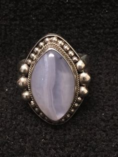 Ring ~ Blue Lace Agate Artist: John Binzley Blue Lace Agate Cabochon Heavy Gage Sterling Silver Size: 6 1/2 Length: 1 1/8 Width: 3/4 Solid Silver Back $280- Blue Lace Agate has a soft, soothing elegance; like sky-blue waters released from winters grasp. Its graceful, circular Pacific Grove, Agate Cabochon, Ring Collection, Ring Blue, Blue Lace Agate, Lace Agate, Blue Rings, Ring Collections, Blue Water