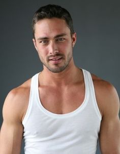 a man in white tank top looking at the camera