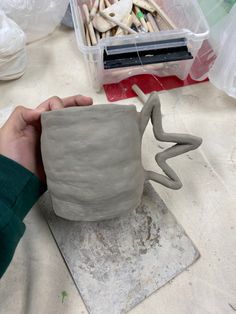 a person is making a clay vase out of clay