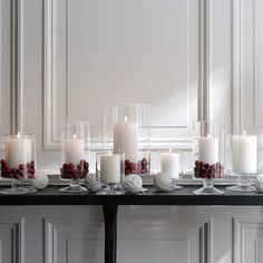 a table topped with lots of white candles