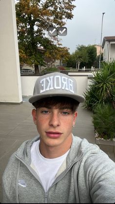 a young man wearing a hat with the word broke written on it in front of him