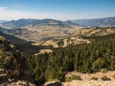 there is a mountain view with many trees in the foreground and mountains in the background