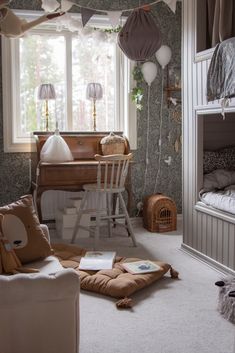 a bedroom with a bed, desk and chair in it's corner next to a window