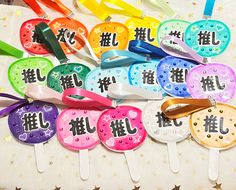 there are many different colored plastic spoons with japanese characters on them and stars in the background