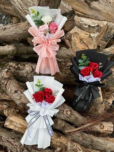 three bouquets of roses tied together in ribbons on top of driftwood, one with pink and white flowers