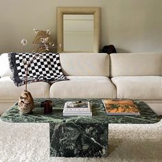 a living room with a couch, coffee table and other items on the rugs