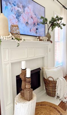 a living room filled with furniture and a fire place covered in a painting on the wall