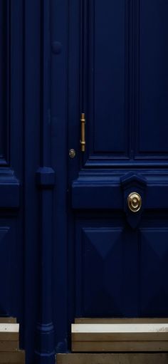 two blue doors with gold handles on them