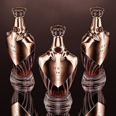 three bottles are shown in front of a black and brown background, one has a red diamond on the top