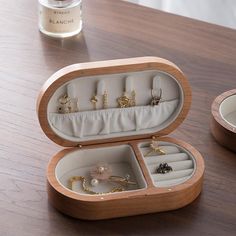 an open jewelry box sitting on top of a wooden table