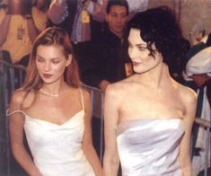 two women in white dresses standing next to each other