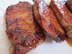 two pieces of meat sitting on top of a white plate