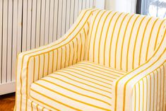 a yellow and white striped chair next to a radiator