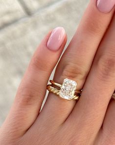 a woman's hand with two gold rings and a diamond ring on her finger