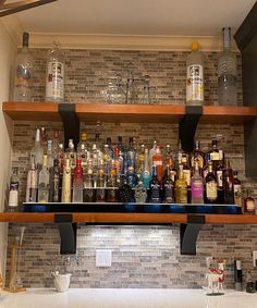 an assortment of liquor bottles on shelves in a kitchen