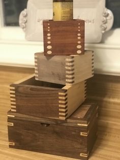 three wooden boxes stacked on top of each other with a bottle in the bottom one