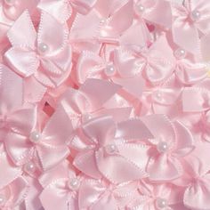 a pile of pink bows with pearls on them