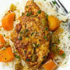 a white plate topped with rice and chicken next to carrots on top of it