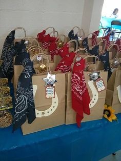 several bags are lined up on a blue table cloth and some have decorations on them