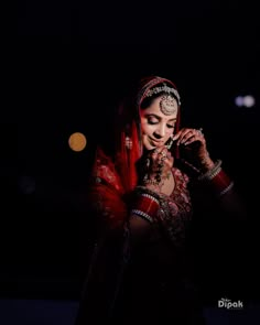 a woman in a red and gold outfit is talking on her cell phone at night