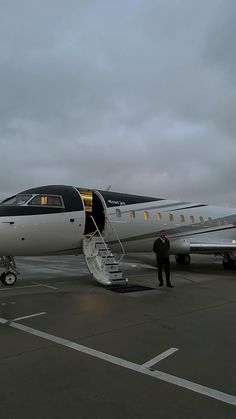 an airplane sitting on the tarmac with stairs leading up to it's door