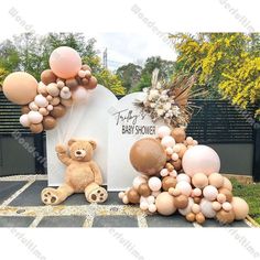 a teddy bear sitting next to balloons and a sign that says, baby showerer