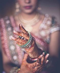 a close up of a woman's hands with hennap