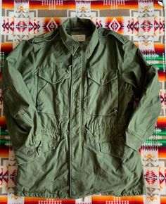 Vintage M-51 field jacket. OG 107 cotton sateen. In very good vintage condition. Small stain on the back right shoulder, see last photo for detail. Conmar Zipper and Scovill snaps are all in good working order. All buttons in tact. Size marked Regular/Small but please refer to the actual measurements: 22 inches from pit to pit measured lying flat, 19 inches across the shoulders, sleeve length is 25 inches and the overall length is 31. inches. Please review all photos, descriptions and measuremen Green Combat Cotton Outerwear, Green Cotton Combat Outerwear, Retro Cotton Utility Jacket For Outdoors, Vintage Cotton Utility Jacket With Multiple Pockets, Vintage Cotton Utility Jacket With Flap Pockets, Vintage Cotton Outerwear With Cargo Pockets, Fall Vintage Parka With Multiple Pockets, Vintage Cotton Parka For Fall, Vintage Fall Parka With Flap Pockets