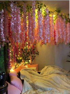 a bed with pink flowers hanging from the ceiling