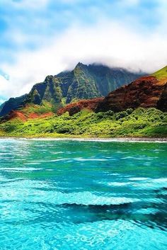 the water is blue and green with mountains in the background