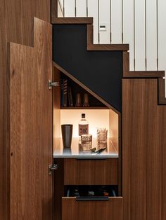 an open cabinet under the stairs in a house