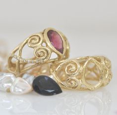 "Unique handmade large 14k gold ring. The large pink Tourmaline center stone is an impressive notable gemstone. Two spirals swivel from both sides of the teardrop Tourmaline and a gentle Celtic design all around the ring. The Diamonds are set on the two sides of the ring to give a unique look, 10 diamonds on each side, this is a very special symmetric design, high and wide yet very light on the finger. The gold finish looks organic. This is defiantly an outstanding gold ring that I am sure you g Gold Tourmaline Rings With Gemstone Accents, Gold Rings With Tourmaline Gemstone Accents, Gold Bohemian Multi-stone Rings, Luxury Multi-stone Ruby Ring In Gold, Luxury Yellow Gold Multi-stone Amethyst Ring, 14k Gold Multi-stone Ruby Ring, Luxury Multi-stone Ruby Ring In 14k Gold, Unique Gold Rings, Pink Tourmaline Ring