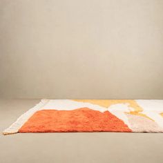 an orange and white area rug on the floor