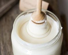 a wooden spoon sticking out of a jar filled with white liquid