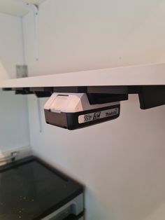 the electronic device is attached to the shelf above the stove