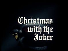 the words christmas with the joker are lit up in the dark, and there is only one light on